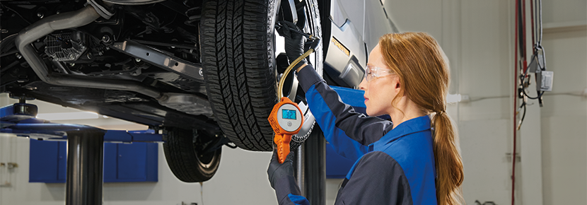 A Subaru technician checking tire pressure. | LaFontaine Subaru in Commerce Township MI