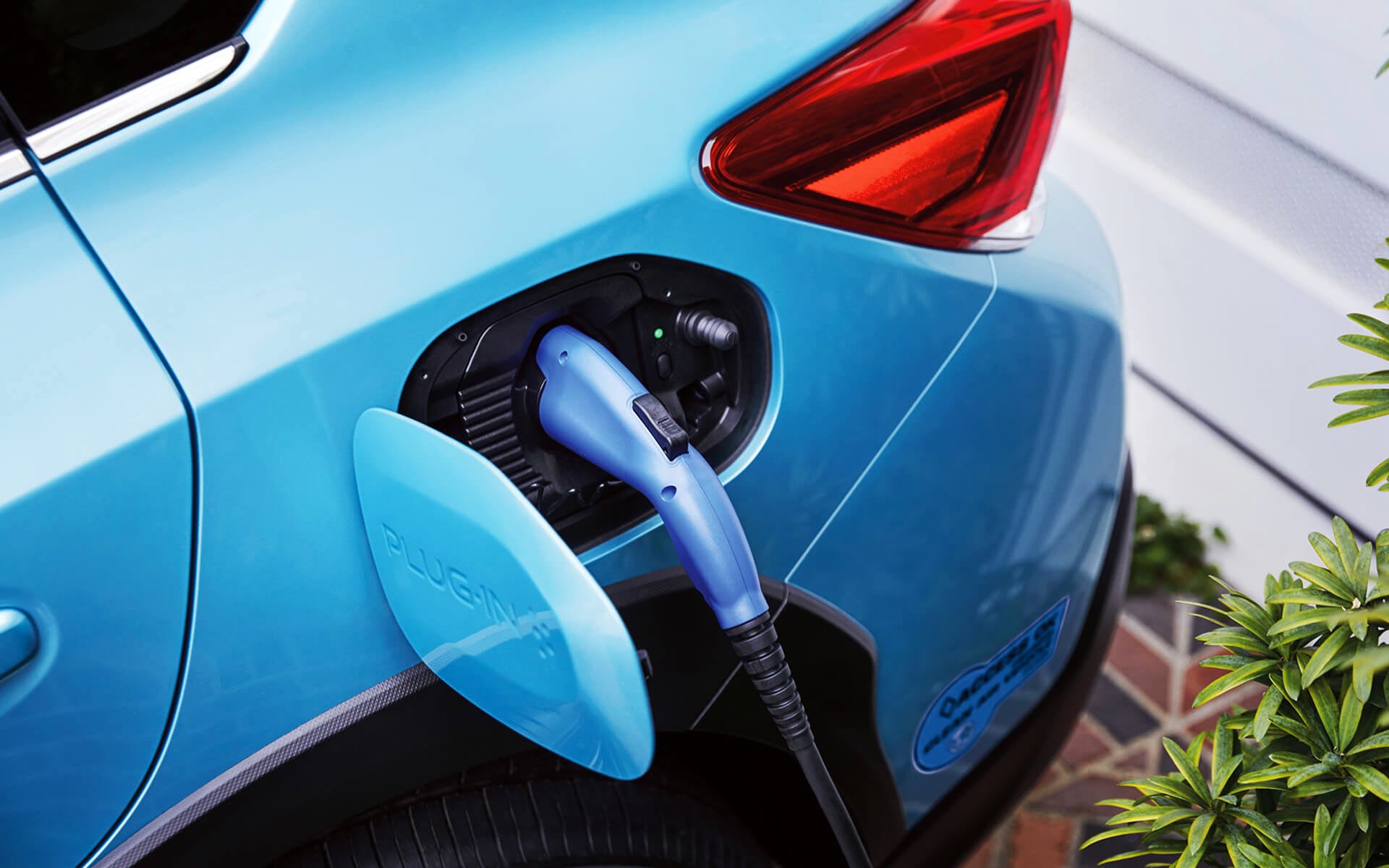 A close-up of the Subaru Crosstrek Hybrid's charging port with charging cable plugged in | LaFontaine Subaru in Commerce Township MI